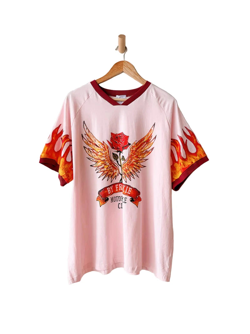 Pink t-shirt with a graphic design on a hanger against a white background